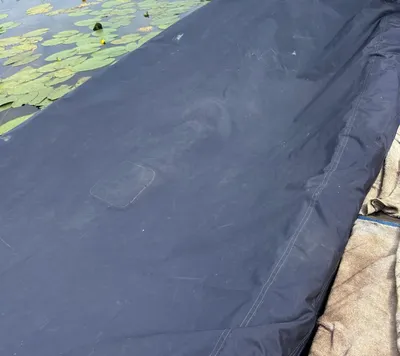 houten sloep met afdekzeil op kanaal