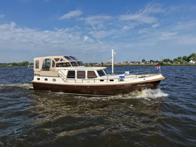 motorjacht varend op binnenwater bij kustlijn