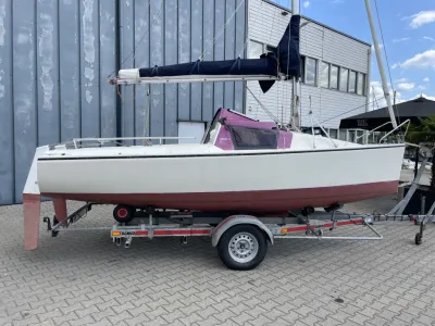 zeilboot op trailer bij loods