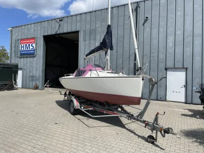 zeilboot op trailer bij loods