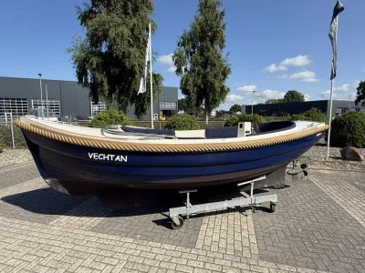 blauwe sloep op trailer bij bedrijfsterrein