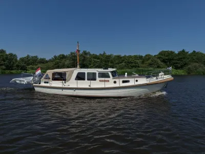 motorjacht varend met bomen op de achtergrond