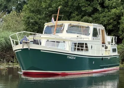 groen-witte motorboot aan de oever