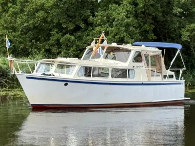 openkuip kruiser op water bij groene oever