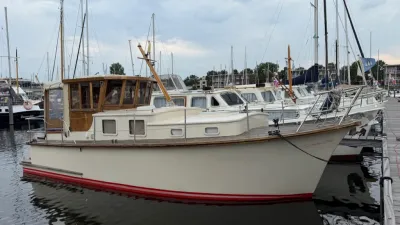 kruiser met houten opbouw afgemeerd in jachthaven