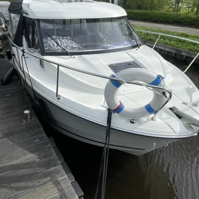 voorkant van witte sportboot afgemeerd aan steiger