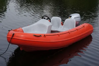 rode kunststof consoleboot op water