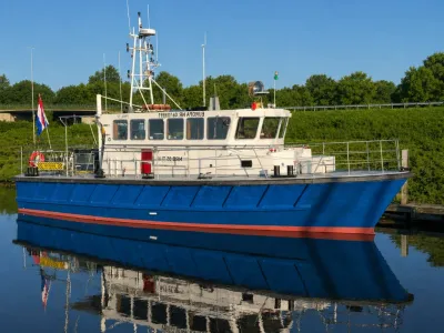 blauw werkschip afgemeerd in kanaal