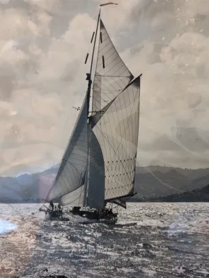 zeilschip op water met bergen op de achtergrond