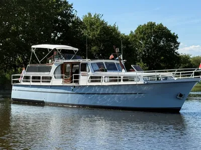 motorjacht op rivier met bomen op achtergrond
