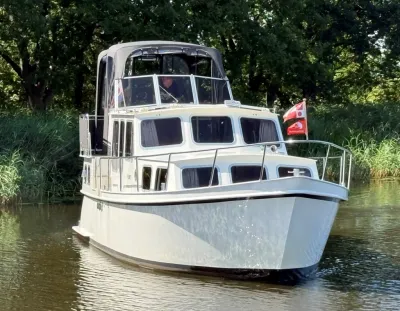 motorkruiser op kanaal met bomen op achtergrond