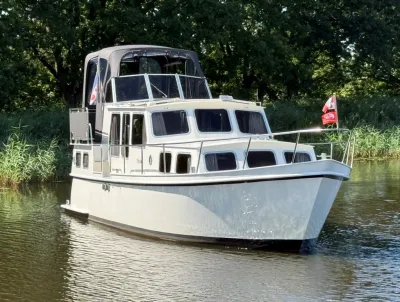 motorjacht op rivier met bomen op achtergrond