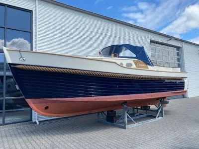kajuitboot op steunen buiten bij loods