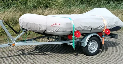 afgedekte rubberboot op trailer bij gras en bomen