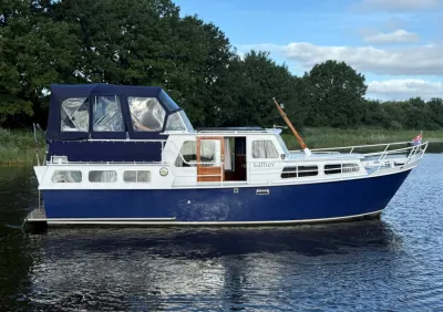 motorjacht op water bij een boomrijke oever