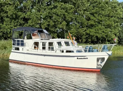wit motorjacht op rustig water bij oever