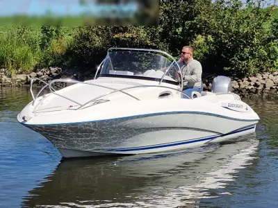 witte consoleboot op rivier met bestuurder