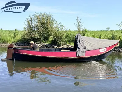 rode boot met dekzeil op water