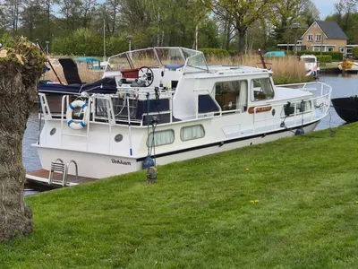 witte motorboot aangemeerd langs oever