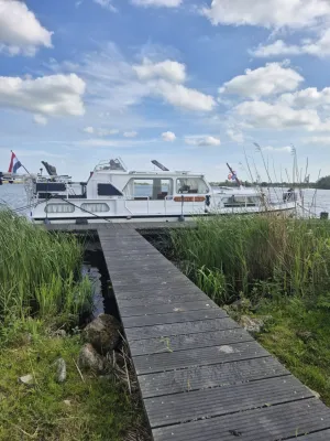 witte motorboot afgemeerd bij steiger
