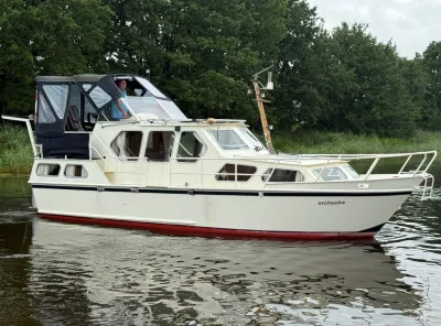motorboot in vaarwater naast groene oever