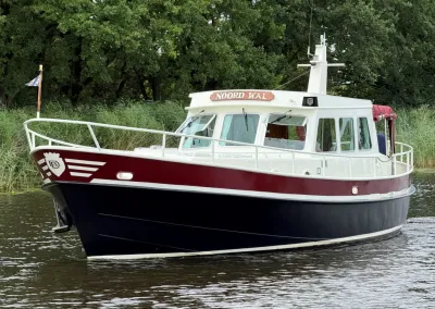 rood-witte motorboot op water bij riet