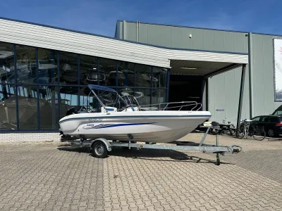 open motorboot op trailer bij bedrijfsgebouw