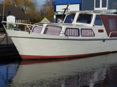 wit motorjacht afgemeerd in water