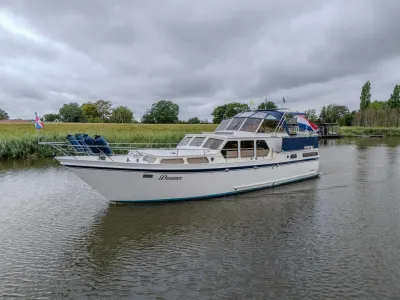 motorjacht in kanaal bij grasoevers