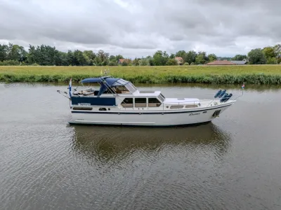 motorjacht op rivier met oever en bomen