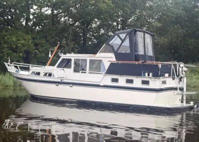 motorkruiser in het water langs de oever