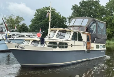 motorjacht afgemeerd op water met bomen
