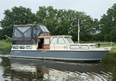 motorjacht in kanaal bij beboste oever