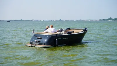 tender op groen water met twee passagiers