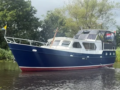 motorjacht op rivier bij groene oever