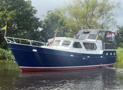 motorjacht op rivier bij groene oever