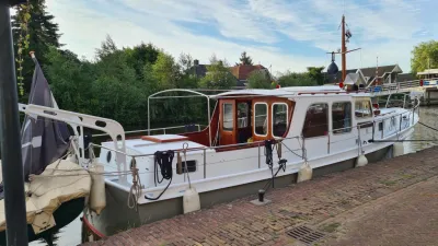 wit motorjacht afgemeerd aan kade