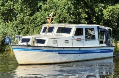 motorcruiser bij een groene oever