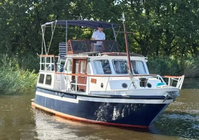 motorkruiser op water met bomen op achtergrond