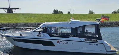 motorjacht langs dijk met molen