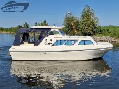 kajuitboot op rustig water bij groene oever