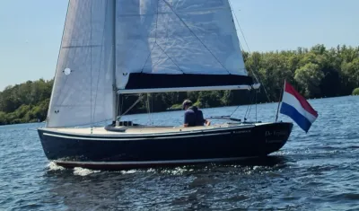 zeiljacht op het water met Nederlandse vlag