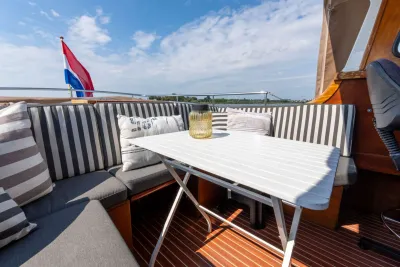 zitgedeelte op dek met tafel en kussens