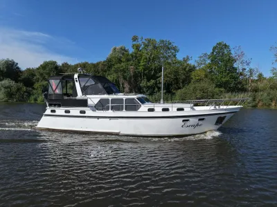 motorjacht op water met bomen op de oever