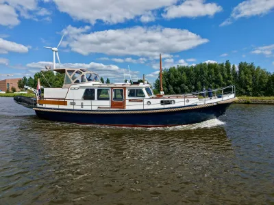 motorjacht op rivier langs groene oever