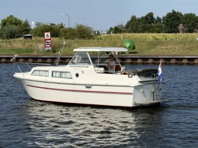witte motorboot op water bij oever