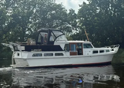 motorjacht liggend in rustig water bij bomen