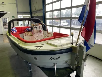 witte sloep met rood interieur in loods
