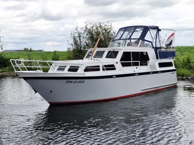 wit motorjacht op water bij groen talud