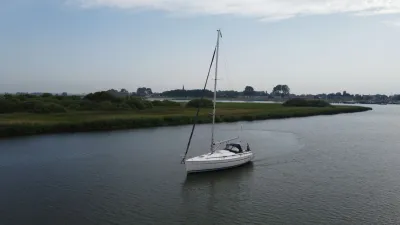 zeiljacht op rivier met oeverlandschap